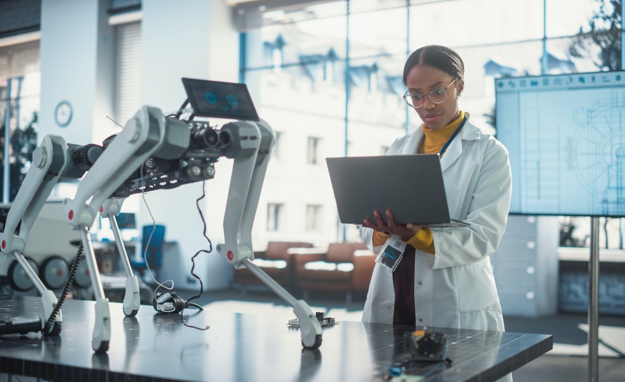 Specialist in lab using laptop to test an AI robotic