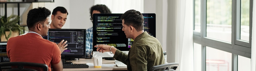 Operations team working on computers at conference table