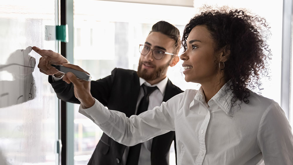 Man and woman working with a whiteboard