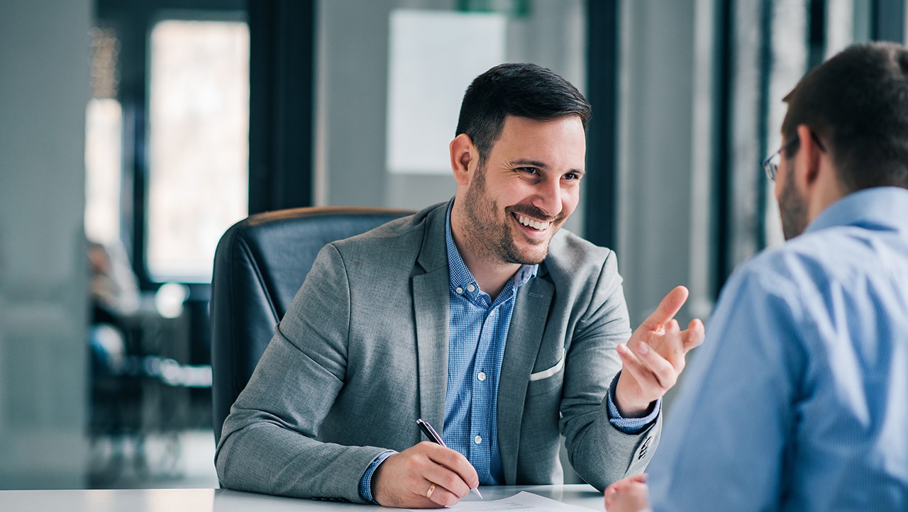 Two professionals having a discussion at a desk