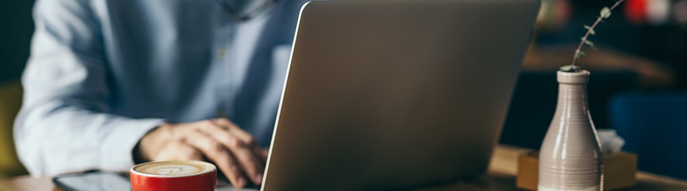 Professional working on laptop with a cup of coffee