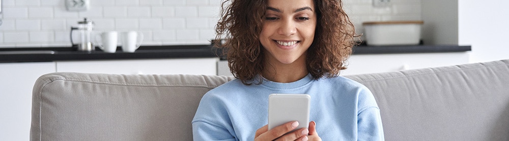 person on a sofa using an app on mobile phone