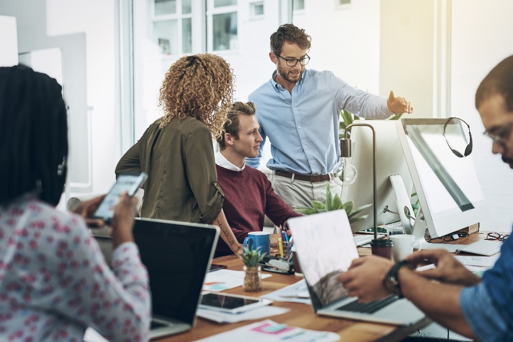 Professionals meeting in front of a computer monitor
