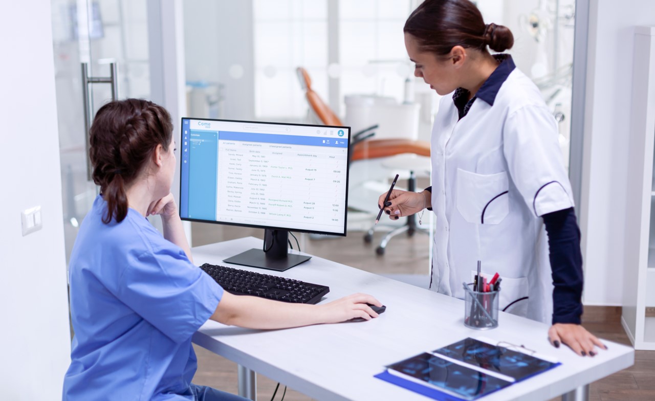 two dental professionals looking at computer screen
