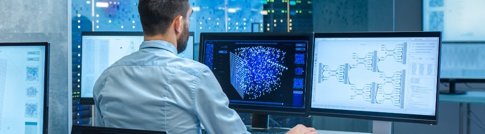 Man working with big monitors