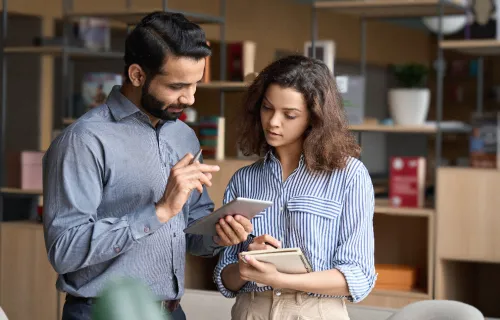 Manager tenant une tablette numérique et discutant avec un employé