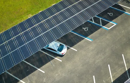 aerial view of car parked in lot beneath solar panel roof