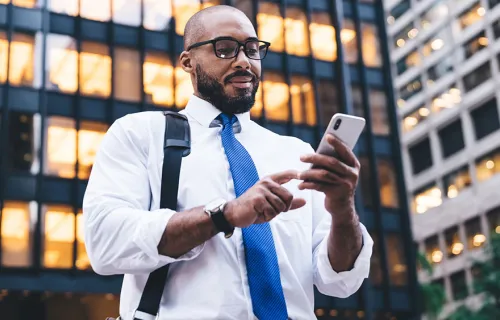 Business person with phone outside building