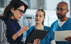 consultant discussing data on a tablet with healthcare professionals