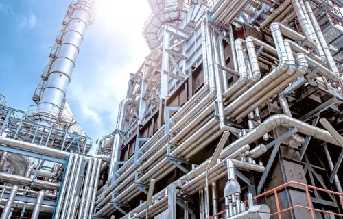 looking up from the center of a refinery to blue sky