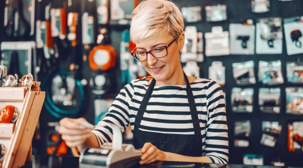 female worker short blonde hair using cash register in bicycle store