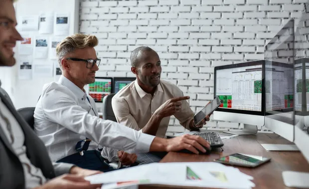 Global trade professionals viewing financial data on computers