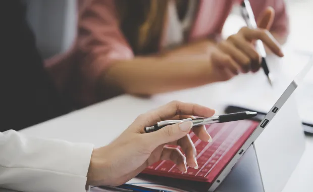 A women pointing at the laptop