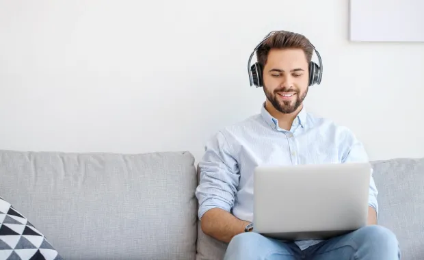 A man sitting on a couch with a lap top