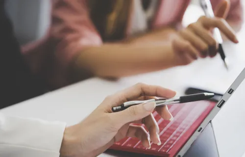 A women pointing at the laptop
