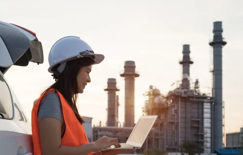 Utilities worker working on laptop in field